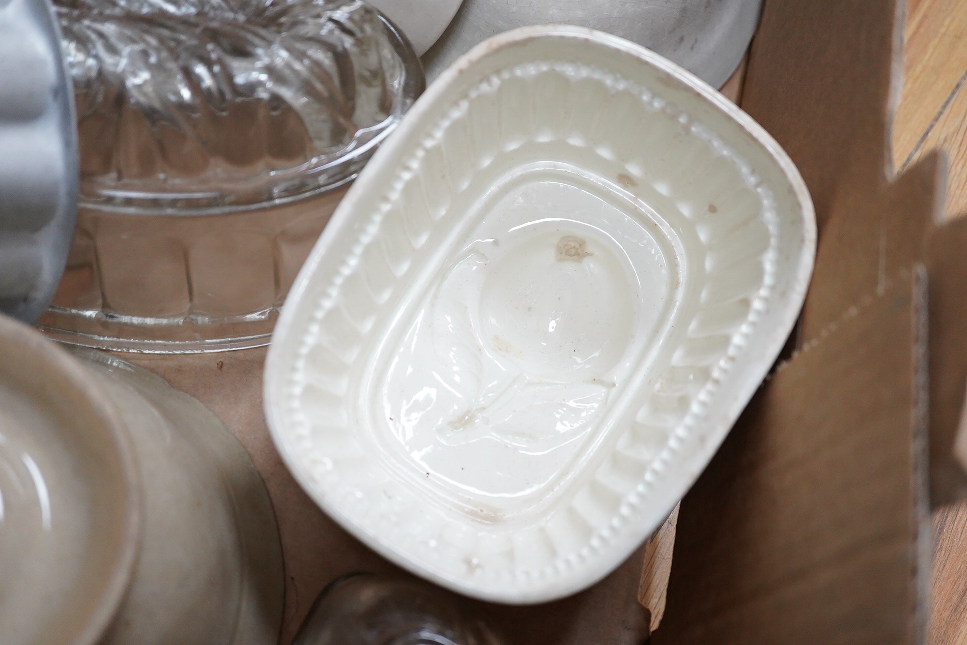 A collection of mostly Victorian ceramic and later glass and metal jelly moulds